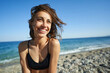 © vitaliymateha - Outdoor shot of smiling young female model enjoying at sea beach against blue sky. Woman having fun out on a summer day.