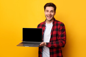 Poster - Happy young man showing black empty laptop screen