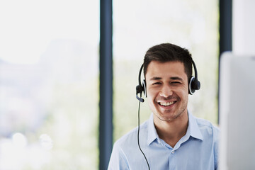 Poster - Creating an effortless customer service experience. Portrait of a happy young man wearing a headset and using a computer at work.