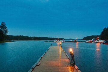 Wall Mural - Sweden. Beautiful Wooden Pier Near Lake In Summer Evening Night. Lake Or River Landscape. Riverside