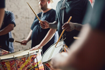 Wall Mural - Can you feel the beat. Closeup shot of a musical performer playing drums with his band.