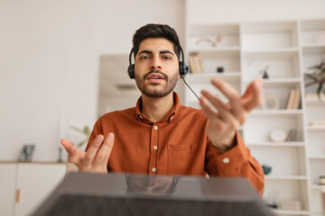 Poster - Arab man using laptop wearing headset sitting at desk