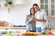 © BestForYou - Young beautiful couple with juice standing at kitchen. Healthy eating, time together