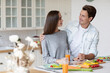© BestForYou - Smiling young couple looking at each other while having breakfast in kitchen.