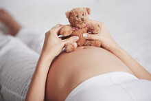Baby Bump Bonding. Shot Of A Pregnant Woman Holding A Teddy Bear On Top Of Her Belly.