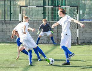 Junior football teams having scrimmage and struggling for ball