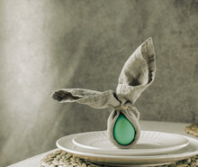 Festive Easter Table Setting. Funny Easter Bunny Made Of Green Egg And Linen Napkin On Plate. Gray Background
