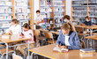 © JackF - Portrait of preteen girl in protective mask reading books in college library