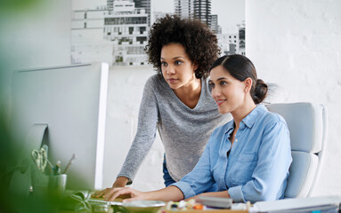 Poster - getting advice from the best. cropped shot of two casually dressed businesswoman looking at somethin