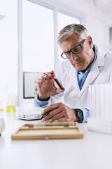Aufkleber - Its easier to log detailed observations with technology. Shot of a mature scientist analyzing a test tube while using a digital tablet in a lab.