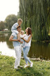 © hetmanstock2 - Happy family resting in park near the lake