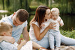 © hetmanstock2 - Happy family have a picnic in park near the lake
