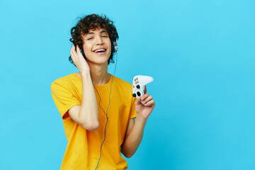 curly guy plays with joystick in yellow t-shirts technologies