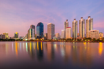 Wall Mural - Scenic view of a lake at the Benjakiti (Benjakitti) Park and skyscrapers in Bangkok, Thailand, at sunset.