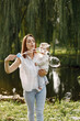 © hetmanstock2 - Young mother holding her little daughter in a hands and blow a soap bubbles