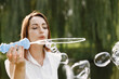 © hetmanstock2 - Woman blow a soap bubbles while standing in a park