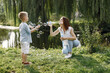 © hetmanstock2 - Young mother resting with her son in a park and blowing a soap bubbles