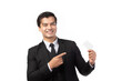 © ueaphan - Handsome business man in black suit holding and finger pointing to credit card isolated on white background. Business, technology, ecommerce and online payment concept.