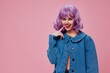 Pretty young female purple hairstyle red lips denim jacket fun pink background unaltered