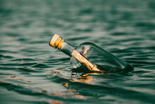 Message In A Bottle Floating On The Ocean Waves. Calling For Help.