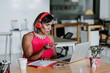 © Marcos - Latin transgender woman working with computer and headphones at the office in Mexico Latin America