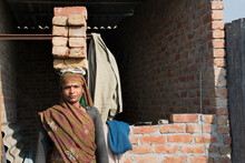 Portrait Of A Woman Labourer Holding Bricks On Her Head