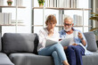 © offsuperphoto - senior couple reading a book and self learning in living room