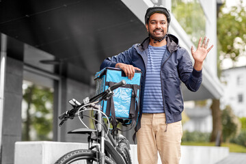 Poster - food shipping, profession and people concept - happy smiling delivery man with thermal insulated bag and bicycle on city street waving hand