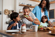 © Chanelle Malambo/peopleimages.com - The boy just cant resist a good breakfast. Shot of a family of four enjoying breakfast together at home.