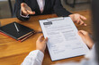 © crizzystudio - Employer or Head of Resources Reading resume and discussing job applicants' resumes. An employer in a suit is interviewing for a job. Resource Manager Hiring Ideas and recruiting concept