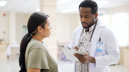 Smart male doctor holding medical prescription talking with unhealthy female patient explaining how to take care of health after come back home