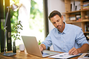 Making sure the numbers add up. Shot of a young man working from home.