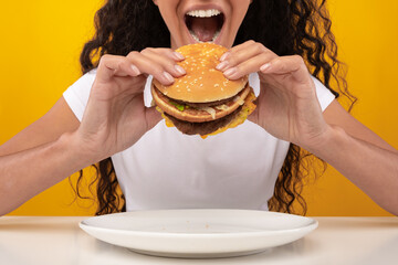 Wall Mural - Closeup Of Lady Holding Burger Biting Sandwich At Studio