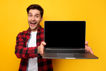 Poster - Excited young man showing black empty laptop screen