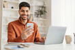 © Prostock-studio - Portrait of smiling man using smartphone and pc at home