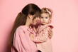 © master1305 - Portrait of young woman and little girl, mother and daughter isolated on pink studio background. Mother's Day celebration. Concept of family, childhood, motherhood