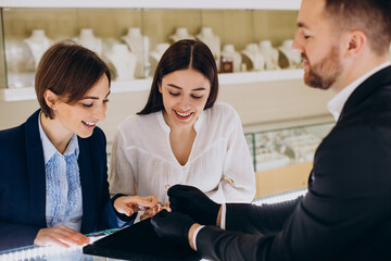 Wall Mural - Couple at jewelry store choosing a ring together