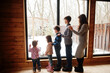 © AS Photo Family - Mother and four kids in modern wooden house against large window.