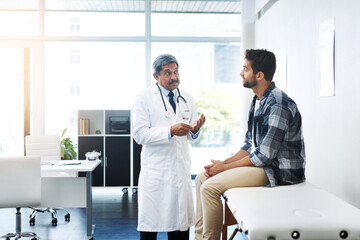 Sticker - What seems to be the matter sir. Shot of a mature male doctor and patient having a discussion in the doctors office before a checkup.