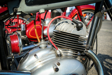 The detail of the polished old motorbike with the two stroke engine. The head has ribbing and is air cooled. 