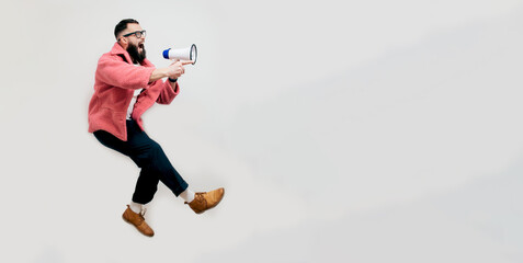 Wall Mural - Funny portrait of an emotional energetic man jumping running isolated over white background with a megaphone. Collage in magazine style. Discount, sale season. Information concept. Attention news!