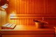 Wooden bucket with spoon on bench in sauna interior