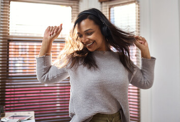 Sticker - And if the music is good, you dance. Shot of a young woman dancing while listening to music at home.