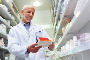 Sticker - Hes meticulous when it comes to medicinal management. Shot of a mature pharmacist doing inventory in a pharmacy.