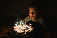 A Little Girl Blows Out Candles On Her Birthday Cake.