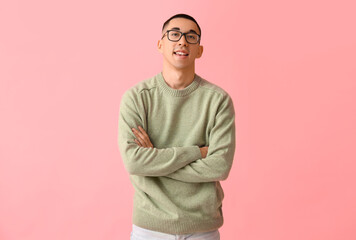 Wall Mural - Handsome young Asian man in knitted sweater on pink background