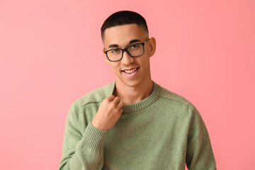 Wall Mural - Handsome young Asian man in knitted sweater on pink background