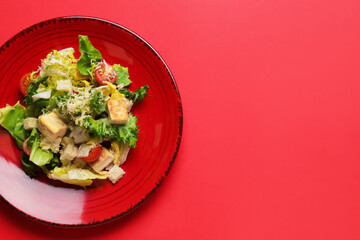 Plate with tasty vegan Caesar salad on red background