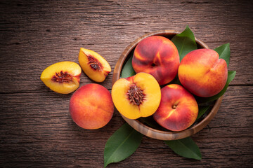 Wall Mural - Yellow Peach with slice in wooden basket, Fresh Yellow Peach fruit in wooden bowl on wooden background.