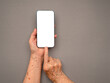 © meeboonstudio - Top view of old woman hand holding a mobile phone with copy space for text over a gray background